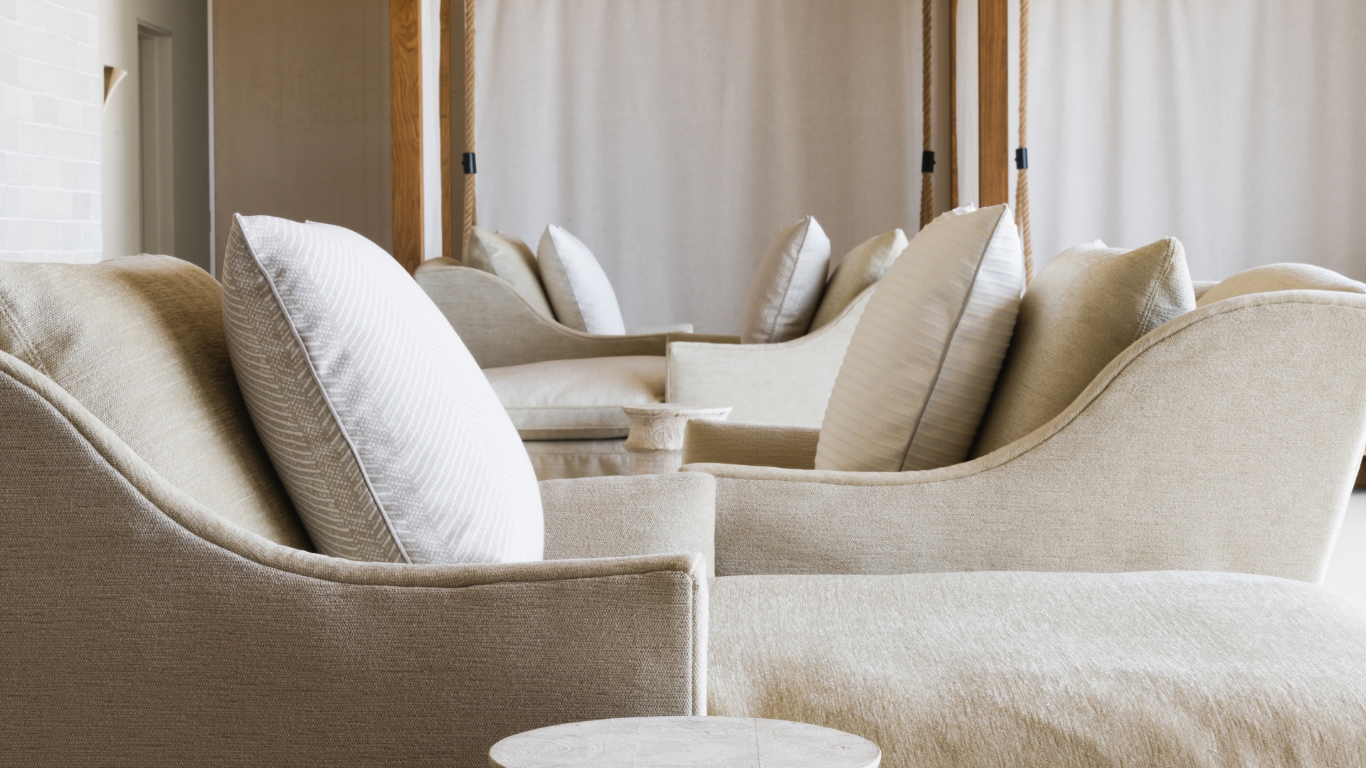 Cozy room with white chairs and cushions in The Spa at Inns of Aurora.